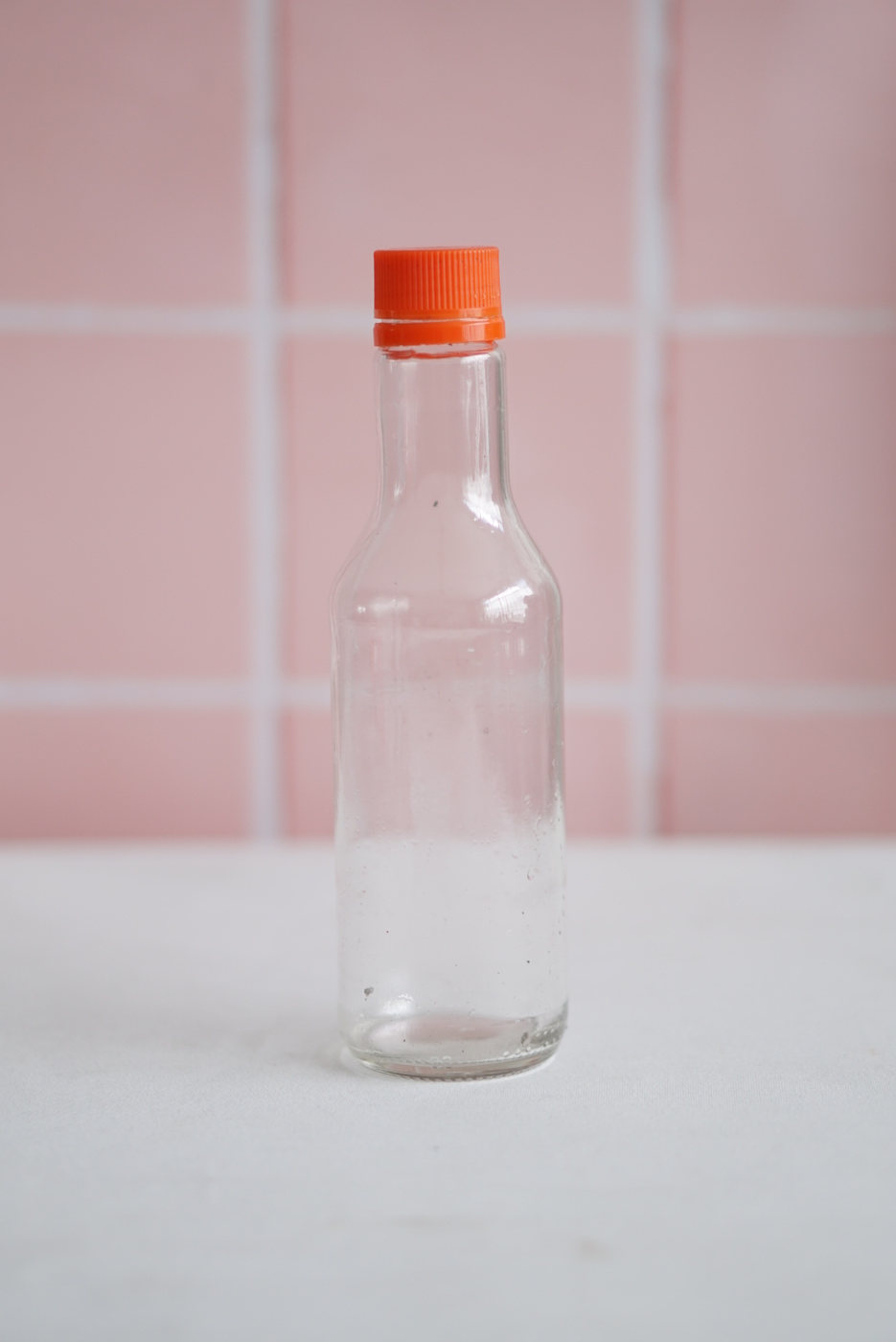 BOTELLA VIDRIO MEDIANA CON TAPA NARANJA